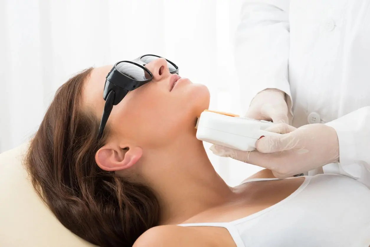 A woman getting her face waxed at the spa