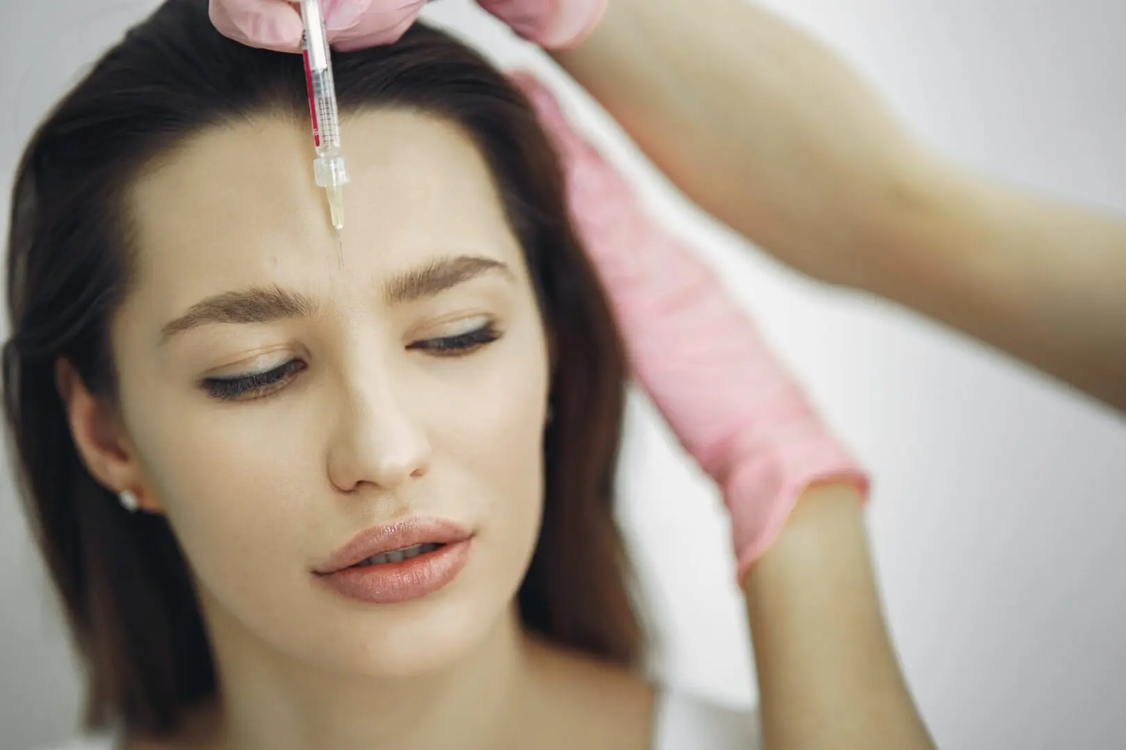 A woman getting botox injection in her face.