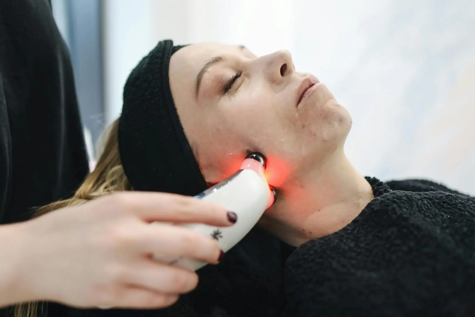 A woman getting her face illuminated by red light.